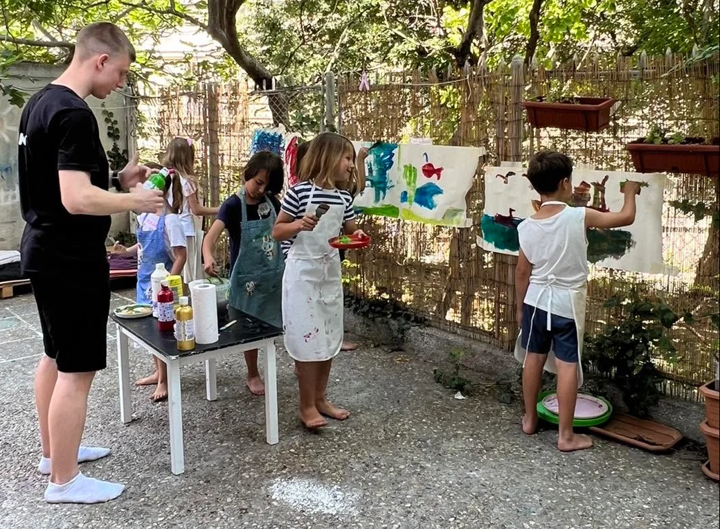 Дети рисуют красками на природе в летнем лагере Tiny Art Club